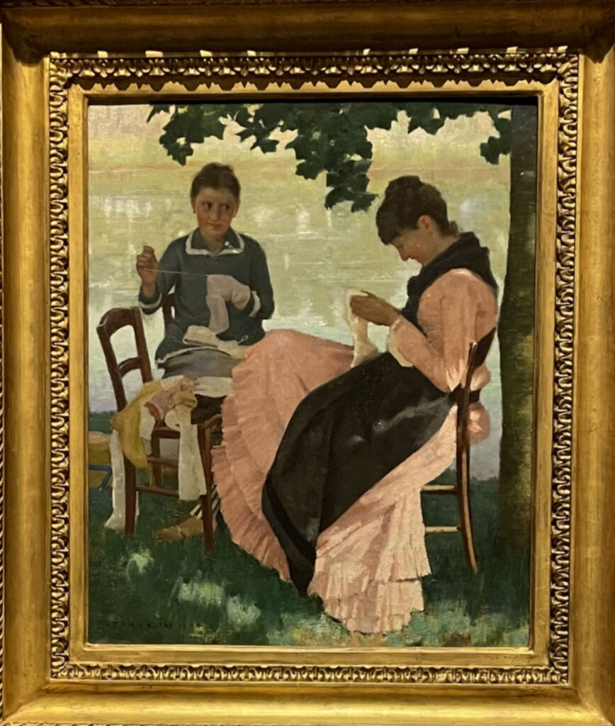 Two late 19th century women sitting sewing in the shade of a tree